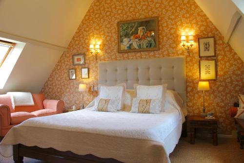 1 dormitorio con 1 cama grande y 1 silla en La Métairie des Songes, en Gourdon-en-quercy