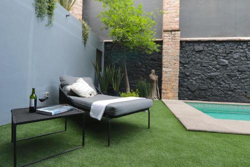 a garden with a couch and a table and a pool at Hotel Boutique Casa Loreta in Querétaro