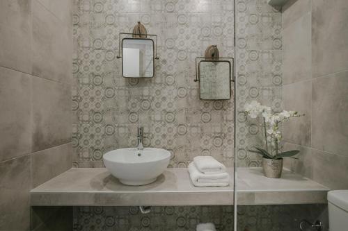 a bathroom with a sink and a mirror at Socrates Apartments in Skala Kefalonias