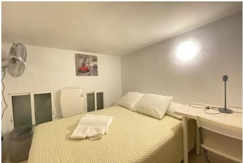 Habitación blanca con 1 cama con 2 toallas. en ILE BUENA VISTA EXTERIO en Madrid