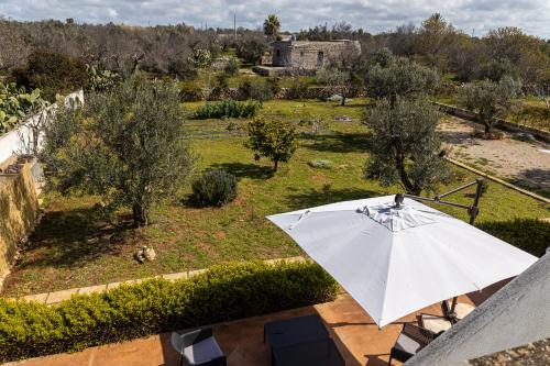 a white umbrella sitting on top of a patio at SalentOspita Guest Rooms in Torre San Giovanni Ugento