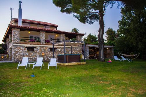 a group of white chairs in front of a house at VILLA GEM in Skiathos Town