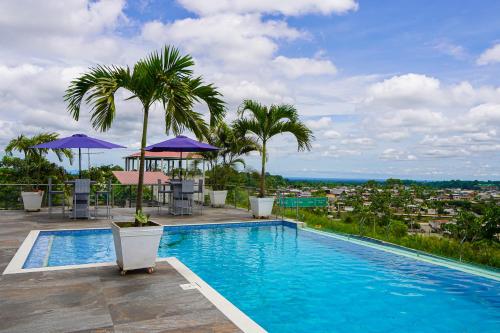 a swimming pool on top of a building with palm trees at THE VIEW HOTEL in Cumanda