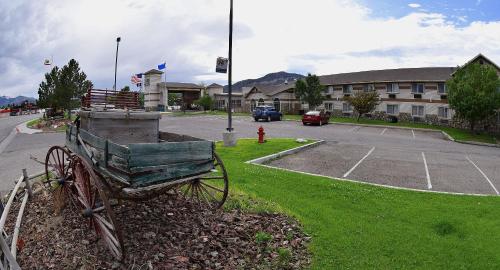 a wooden cart sitting in the grass near a parking lot at Prospector Hotel & Casino in Ely