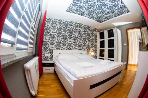 a bedroom with a bed with a blue and white patterned wall at Apartament Książęcy Premium klimatyzacja 3 SYPIALNIE 3 BEDROOMS in Bolesławiec