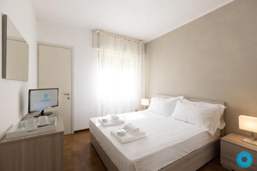 a bedroom with a white bed and a television at Maji Como Lake Varenna in Varenna