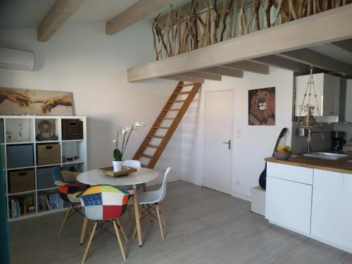 une cuisine avec une table et des chaises ainsi qu'un escalier dans l'établissement Azzura, duplex lumineux accès direct à la plage, à Sainte-Maxime