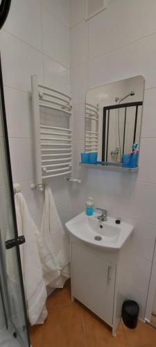 a white bathroom with a sink and a mirror at ZATOR Noclegi u Babci Józi in Zator