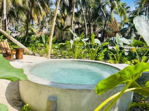 a hot tub in a garden with palm trees at Maya Tulum By G Hotels in Tulum