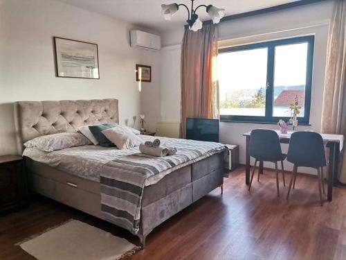 a bedroom with a large bed and a table and chairs at Guest House Sunce in Novi Vinodolski