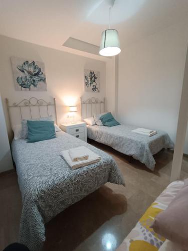 a bedroom with two beds with blue pillows at Lara Cazorla in Cazorla