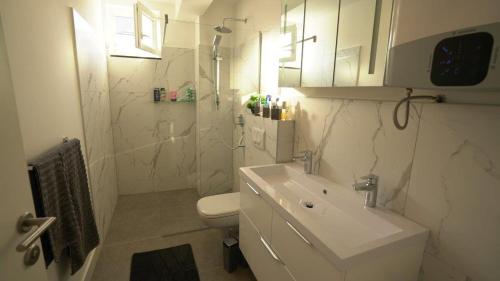 a white bathroom with a sink and a toilet at Villa Lana in Nin