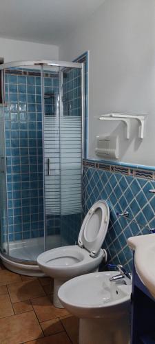 uma casa de banho com um WC e uma cabina de duche em vidro. em Casa Agnese em Marina di Camerota