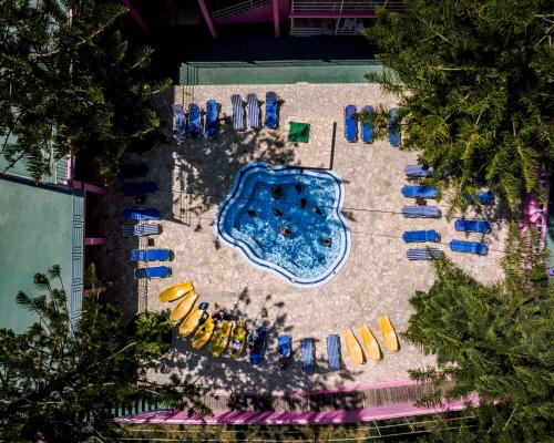 an overhead view of a pool with yellow and blue chairs at The Pink Palace Hostel in Agios Gordios