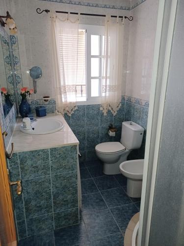 a bathroom with a sink and a toilet and a window at Casa Almoraima in Gaucín