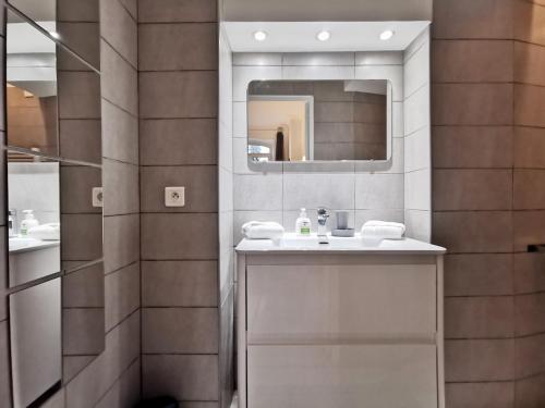 une salle de bain avec un lavabo et un miroir dans l'établissement Le jardin Clémenceau by Booking Guys, à Nice