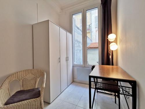 une pièce avec une table, une chaise et une fenêtre dans l'établissement Le jardin Clémenceau by Booking Guys, à Nice