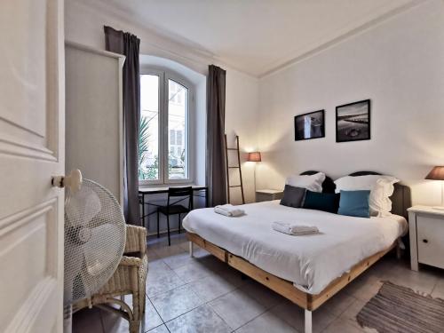 une chambre avec un lit, un bureau et une fenêtre dans l'établissement Le jardin Clémenceau by Booking Guys, à Nice