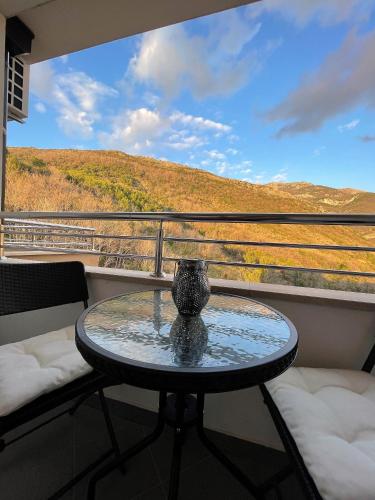 a table and chairs on a balcony with a view at MonteRelax Apartments Becici in Rafailovici