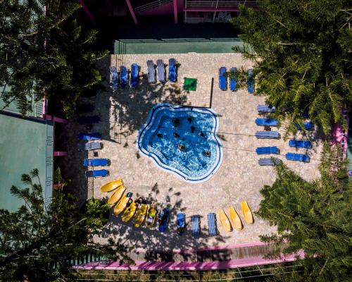 uma vista superior para uma piscina com cadeiras amarelas e azuis em Pink Palace Beach Resort em Agios Gordios