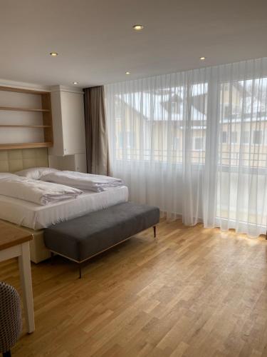 een slaapkamer met 2 bedden en een tafel en ramen bij Zum Franziskaner Dependance in Füssen