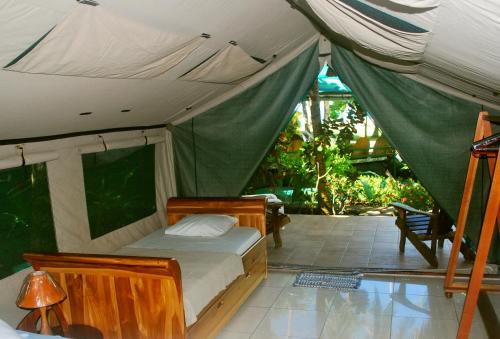 1 dormitorio con 1 cama en una tienda de campaña en Rafiki Beach Camp, en Matapalo