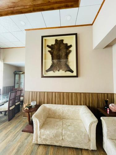 a living room with a couch and a picture on the wall at Panorama Luxury House in Nathia Gali