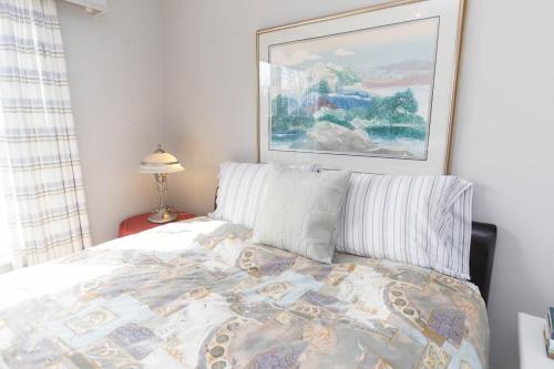 um quarto com uma cama e um quadro na parede em Wilson Vines em Wellington