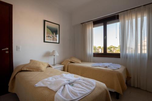 Habitación de hotel con 2 camas y ventana en Edificio Las Arenas en Pinamar