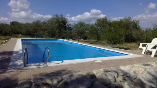 een zwembad met twee stoelen ernaast bij White Field Houses and Spa in Villa Las Rosas