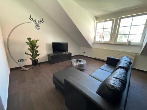 a living room with a couch and a tv at Ferienwohnung Augenblick - Stylisches Apartment in der besten Altstadtlage von Erfurt in Erfurt