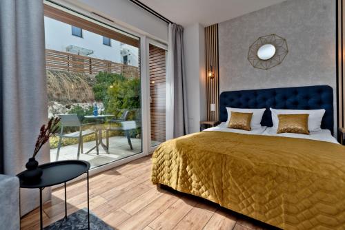 a bedroom with a king sized bed and a balcony at Aparthotel Anchoria BlueApart in Mechelinki