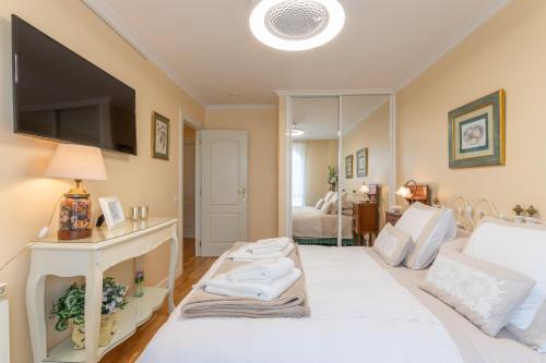 a living room with a white bed and a television at Room Elciego in Elciego