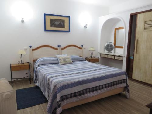 a bedroom with a bed with a blue and white blanket at Villa El Alcazar in Carvoeiro