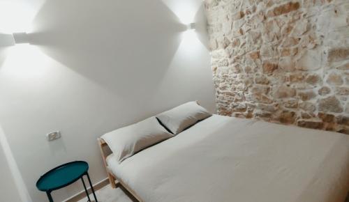 a bedroom with a white bed and a blue chair at PIETRAVIVA Housing in Molfetta