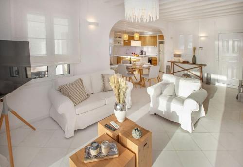 a living room with two white couches and a table at Mykonian house in Elia beach by GHH in Elia Beach