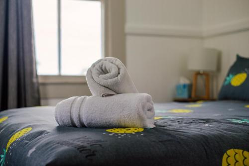a towel animal sitting on the edge of a bed at NEW - Pineapple Loft - Entire House Downtown Hilo with AC in Hilo