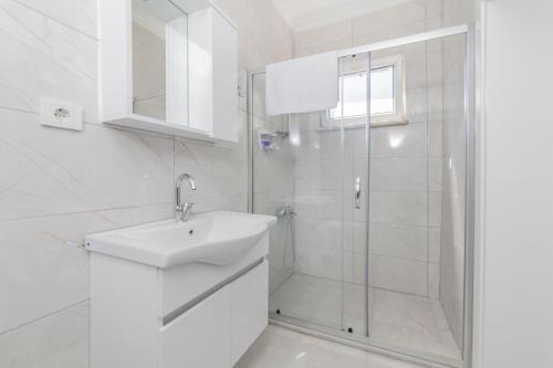 a white bathroom with a sink and a shower at Fresh apartment in authentic neighborhood in Bursa