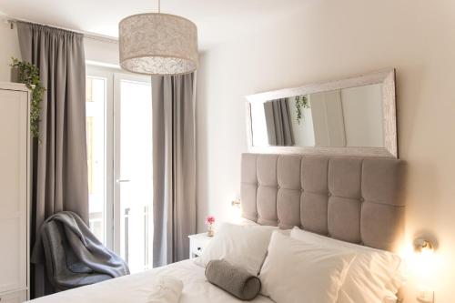 The Perfect Room Zadar في زادار: غرفة نوم بسرير ومرآة فوقها