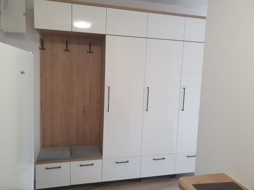 a kitchen with white cabinets and a wooden door at Good Time Apartaments Sienkiewicza in Leszno