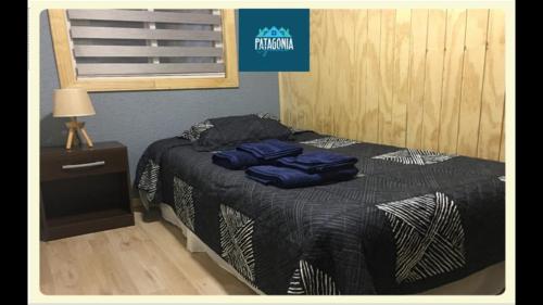 1 dormitorio con 1 cama con 2 almohadas azules en Departamentos Patagonia Garden A, en Punta Arenas