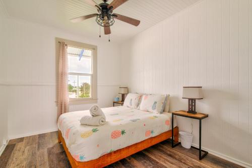 um quarto com uma cama, uma ventoinha de tecto e uma janela em NEW - Pineapple Loft - Entire House Downtown Hilo with AC em Hilo