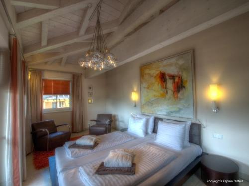 a bedroom with two beds and a chandelier at Residenz an der Burg by Kaprun Rentals in Kaprun