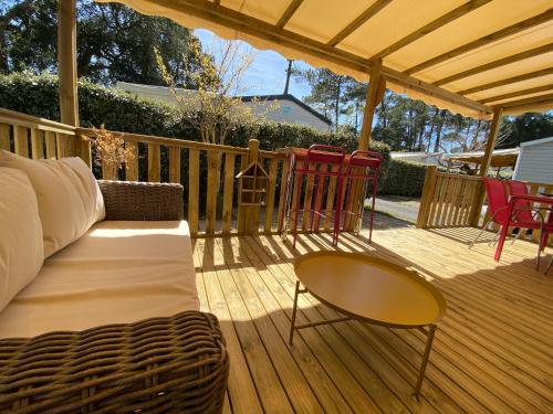 a porch with a couch and a table and chairs at Le Lolipop in Capbreton