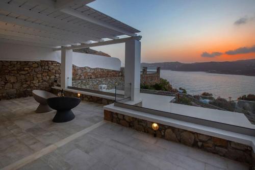 a patio with a view of the ocean at sunset at Mykonian house in Elia beach by GHH in Elia Beach