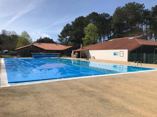 a large swimming pool with a house in the background at Le Lolipop in Capbreton