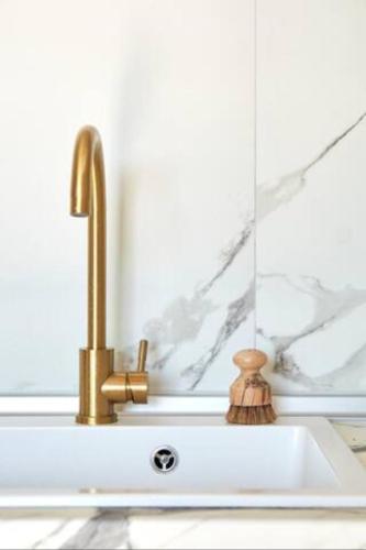 a sink with a faucet next to a mirror at Trie Vineyard Cottage in Grevena