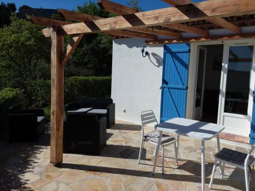 a patio with a table and chairs and a wooden pergola at Luciana in La Croix-Valmer