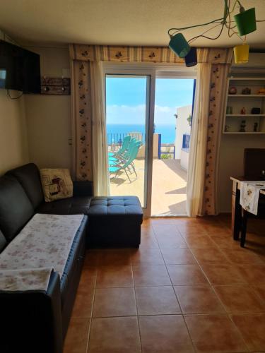 sala de estar con sofá y vistas al océano en Casa Sacy en Villajoyosa