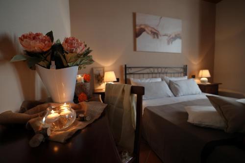 een slaapkamer met een bed en een vaas met bloemen op een tafel bij La Cascina Nel Bosco in Faicchio
